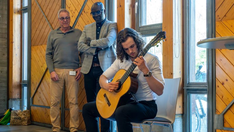 Das Bild zeigt einen Gitarrist mit dem Bezirksvorsteher Herrn Gueye