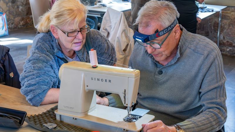 Zwei Personen sitzen vor der Nähmaschiene