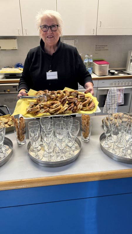 Das Bild zeigt eine Mitarbeiterin an der Theke mit einem Tablet auf dem Brezeln aufgereit sind.